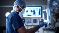 A doctor using equipment to monitor a coronavirus patient